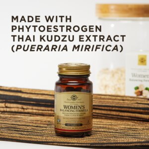 An amber glass bottle of Solgar's Women's Balancing formula tablets in a kitchen setting. The glass bottle is on a natural textured placemat, with the white product box and a jar of oats in the background. The image text says, "Made with phytoestrogen Thai kudzu extract (pueraria mirifica).