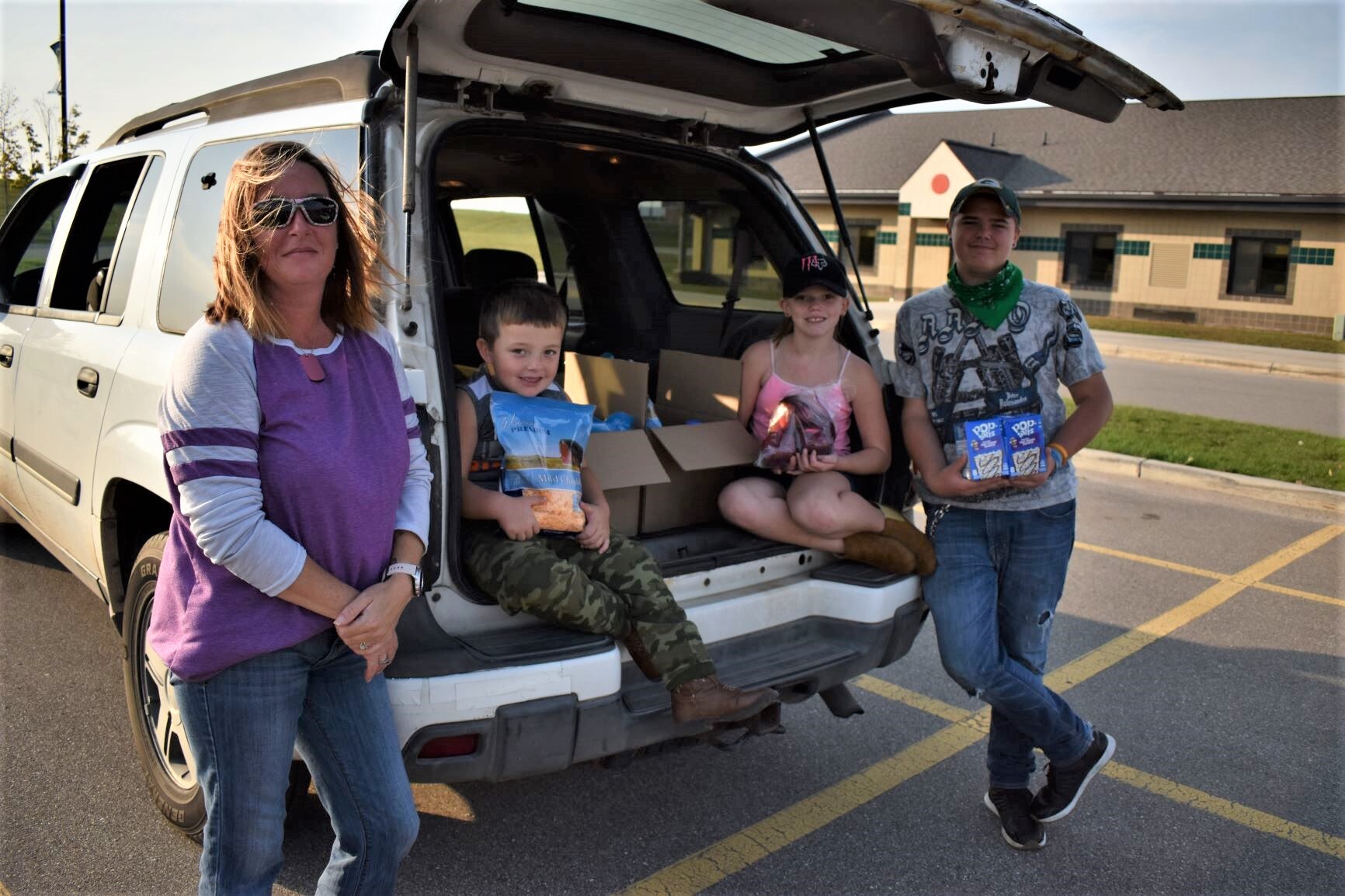 Family with food in the back of a car.