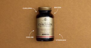 Product shot of Solgar Full Spectrum Circumin in an amberglass bottle against a textured brown background. Four white arrows on four separate corners point towards the bottle. Each arrow is labelled with a different ingredient: circumin, bacopa, choline, vitamin B12.