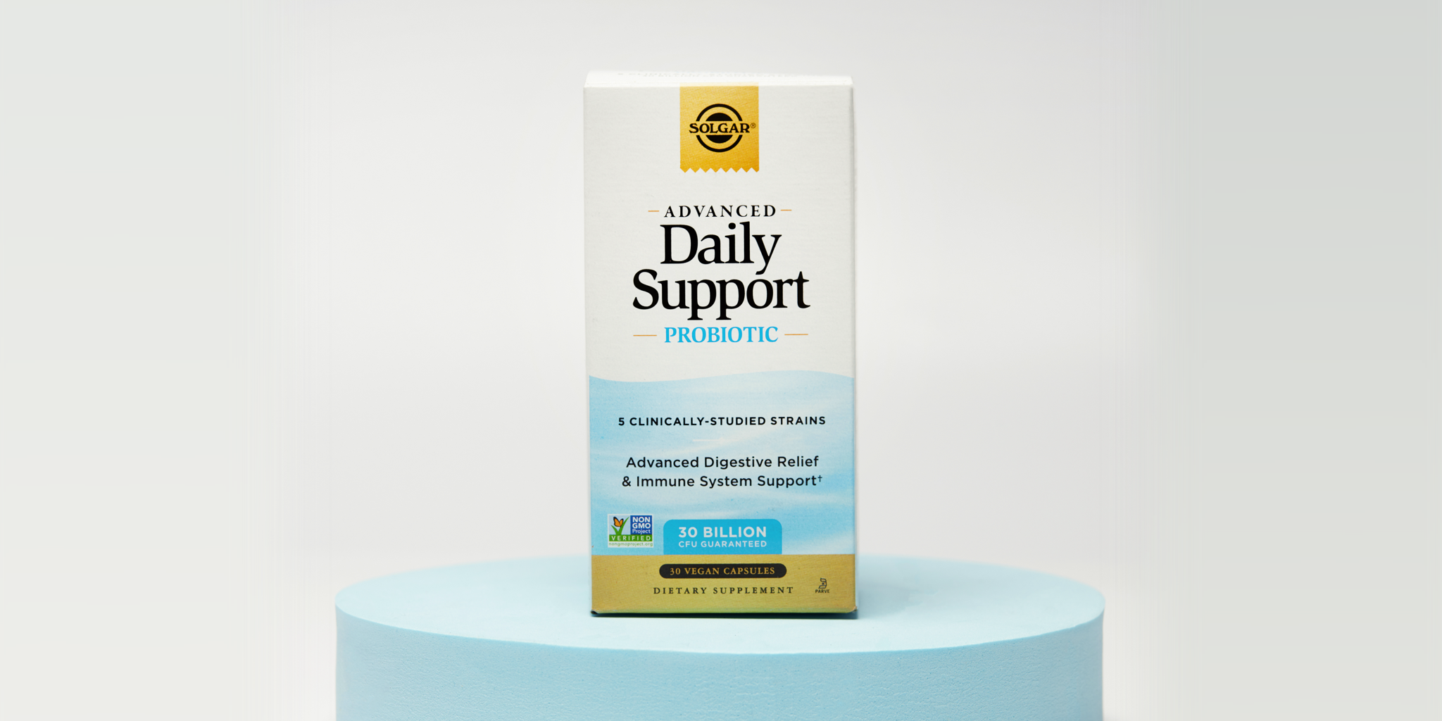 A box of Solgar Advanced Daily Support probiotic sittin on a blue circular riser against a white background.