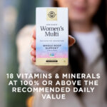 A woman holding a box of Solgar One Daily Women's Mutli supplement in her hand towards the camera. The box is in focus and the woman is blurred with the camera's depth of field. The image says, "18 vitamins and minerals at 100% or above the recommended daily value".