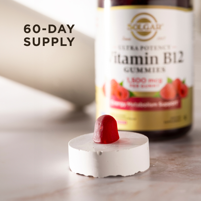 A single serving of Solgar Ultra Potency Vitamin B12 Gummies sitting on a white stone riser on a marble countertop. The gummy and riser is in focus, the bottle of vitamins is visible but blurred in the background. The image says, "60-day supply".
