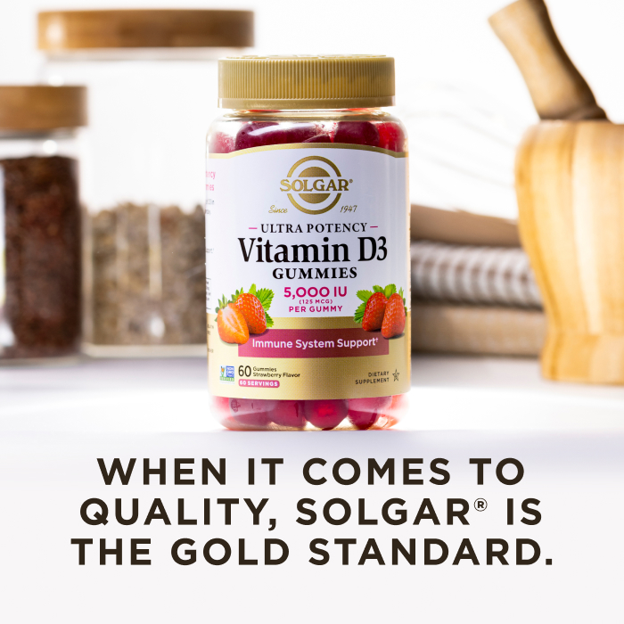 A bottle of Solgar Ultra Potency Vitamin D3 gummies in a kitchen scene on a white countertop. The image says, "When it comes to quality, Solgar is the Gold Standard."