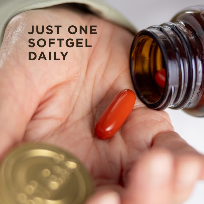 One red softgel capsule of Solgar Joint Ease, being poured from an amber glass bottle into a hand. Text on the image reads, "Just one softgel daily"
