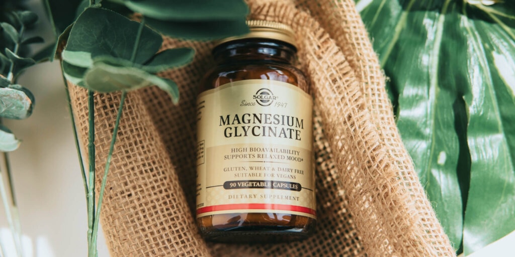 amber glass bottle on a rattan fabric surrounded by green plants 