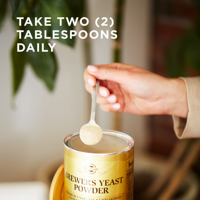An open container of Solgar's Brewer's Yeast Powder with a woman scooping into it with a spoon. Text reads "take two tablespoons daily"