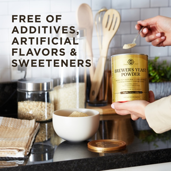 A woman uses Brewer's Yeast Powder in her kitchen with a spoon. Text reads "free of additives, artificial flavors, and sweeteners.