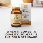 An amber bottle of Solgar's Triple Action Sleep Tri-layer tablets next to its white-and-gold outer packaging on a white surface. Text overlaid reads: "When it comes to quality, Solgar® is the Gold Standard."