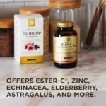 An amber glass bottle of Solgar's Ester-C® Plus Immune Complex softgels sits next to its white-and-gold outer packaging on a marble kitchen surface. A text overlay below reads: "Offers Ester-C®, zinc, echinacea, elderberry, astagralus, and more."