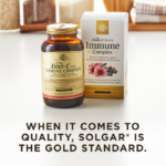 An amber bottle of Solgar's Ester-C® Plus Immune Complex softgels next to its white-and-gold outer packaging on a white surface. Text overlaid reads: "When it comes to quality, Solgar® is the Gold Standard."