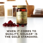 An amber bottle of Solgar Apple Cider Vinegar Gummies sits on a white surface with a heap of gummies next to it. Text overlaid reads: "When it comes to quality, Solgar® is the Gold Standard."