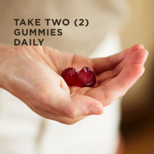 An outstretched hand holds two Solgar Apple Cider Vinegar Gummies. Text overlaid reads "Take two gummies daily."