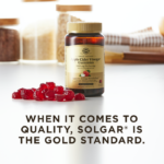 An amber bottle of Solgar Apple Cider Vinegar Gummies sits on a white surface with a heap of gummies next to it. Text overlaid reads: "When it comes to quality, Solgar® is the Gold Standard."