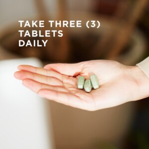 In a woman's upturned palm sits three of Solgar's Earth Source® Multi-Nutrient Tablets. Text reads "take three tablets daily"