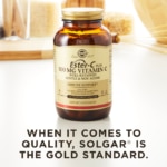 A bottle of Solgar's Ester-C® Plus 500 mg Vitamin C Vegetable Capsules (Ester-C® Ascorbate Complex) on a kitchen countertop. Text reads "When it comes to quality, Solgar is the gold standard."