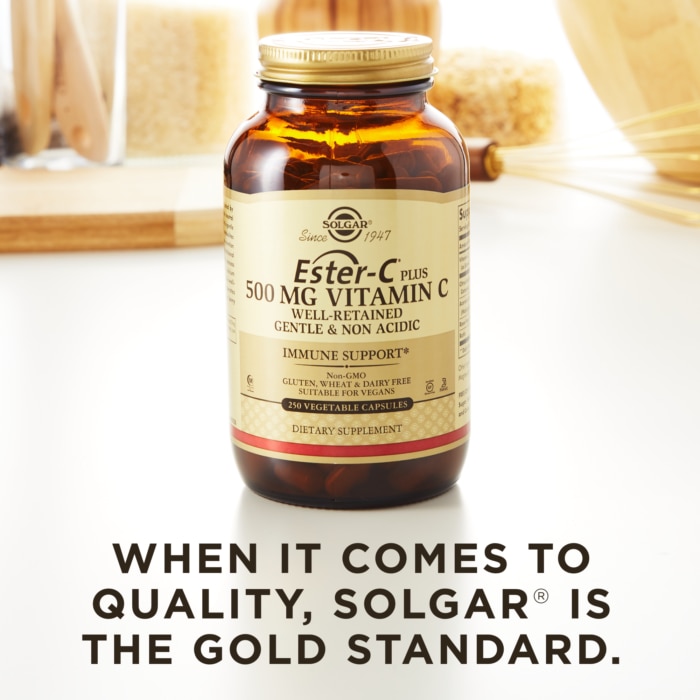 A bottle of Solgar's Ester-C® Plus 500 mg Vitamin C Vegetable Capsules (Ester-C® Ascorbate Complex) on a kitchen countertop. Text reads "When it comes to quality, Solgar is the gold standard."