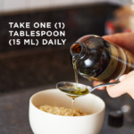 A bottle of Solgar's Earth Source® Organic Flaxseed Oil is being poured into a spoon onto a bowl of food. Text reads "take one tablespoon (15ml) daily"