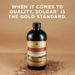 A bottle of Solgar's Earth Source® Organic Flaxseed Oil shown face-on with loose flax seeds around the bottle. Text reads "When it comes to quality, Solgar is the gold standard."