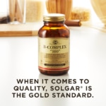 A bottle of Solgar's B-Complex "100" vegetable capsules on a kitchen surface. Text reads "when it comes to quality, Solgar is the gold standard."