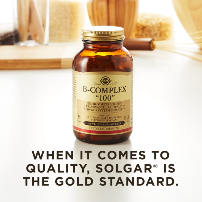 A bottle of Solgar's B-Complex "100" vegetable capsules on a kitchen surface. Text reads "when it comes to quality, Solgar is the gold standard."