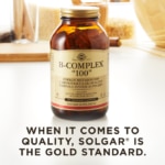 A bottle of Solgar's B-Complex "100" vegetable capsules on a kitchen surface. Text reads "when it comes to quality, Solgar is the gold standard."