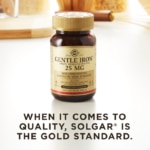 A bottle of Solgar's Gentle Iron Vegetable Capsules on a kitchen countertop. Text reads "When it comes to quality, Solgar is the gold standard."