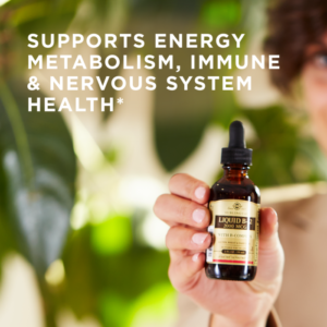 An amber bottle of Solgar's Sublingual Liquid B-12 2000 mcg with B-Complex held up in front of a background of plant leaves. Text reads "supports energy metabolism, immune and nervous system health"