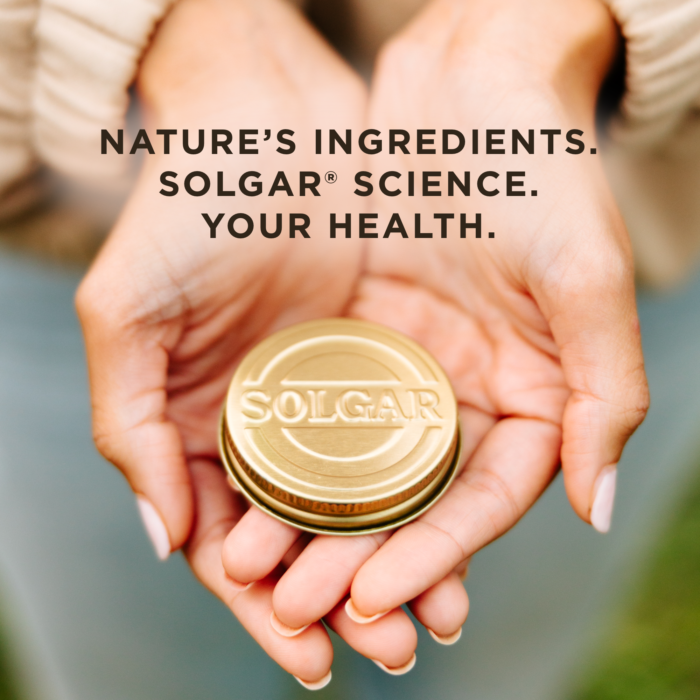 A golden lid from the bottle of a Solgar product in the outstretched palms of a woman's hands, with text overlaid reading: "Nature's ingedients. Solgar science. Your health."