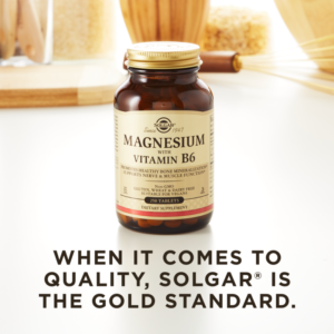A bottle of Solgar's Magnesium with Vitamin B6 Tablets on a kitchen countertop. Text reads "When it comes to quality, Solgar is the gold standard."