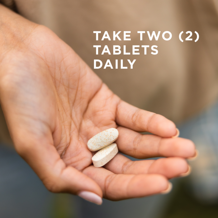Two tablets of Solgar's Skin, Nails & Hair supplement held in an outstretched hand. Text says "take two tablets daily"