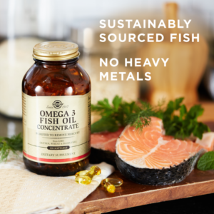 Solgar's Omega-3 Fish Oil Concentrate Softgels next to some kale and prepared fish. Text reads "sustainably sourced fish, no heavy metals"