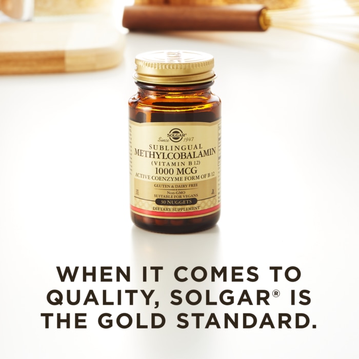 A bottle of Solgar's Methylcobalamin Vitamin B12 nuggets on a kitchen countertop. Text reads "When it comes to quality, Solgar is the gold standard."