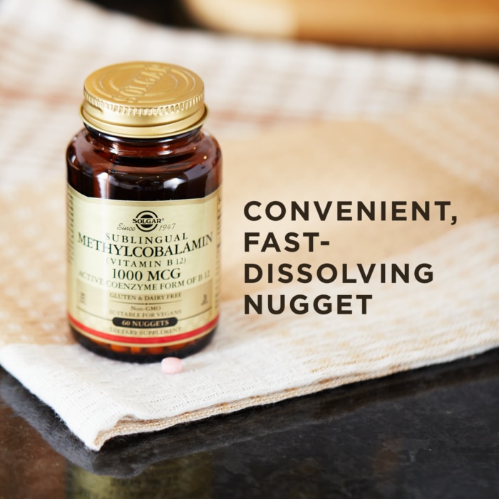 A bottle of Solgar's Methylcobalamin Vitamin B12 on a cloth surface. Text reads "convenient, fast-dissolving nugget"