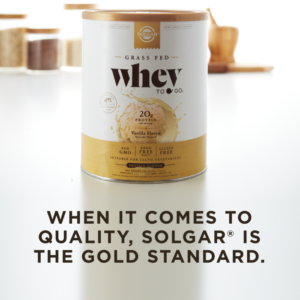 A container of Solgar's Whey To Go® vanilla-flavored protein powder on a kitchen counter, with text overlaid that reads "When it comes to quality, Solgar is the gold standard."