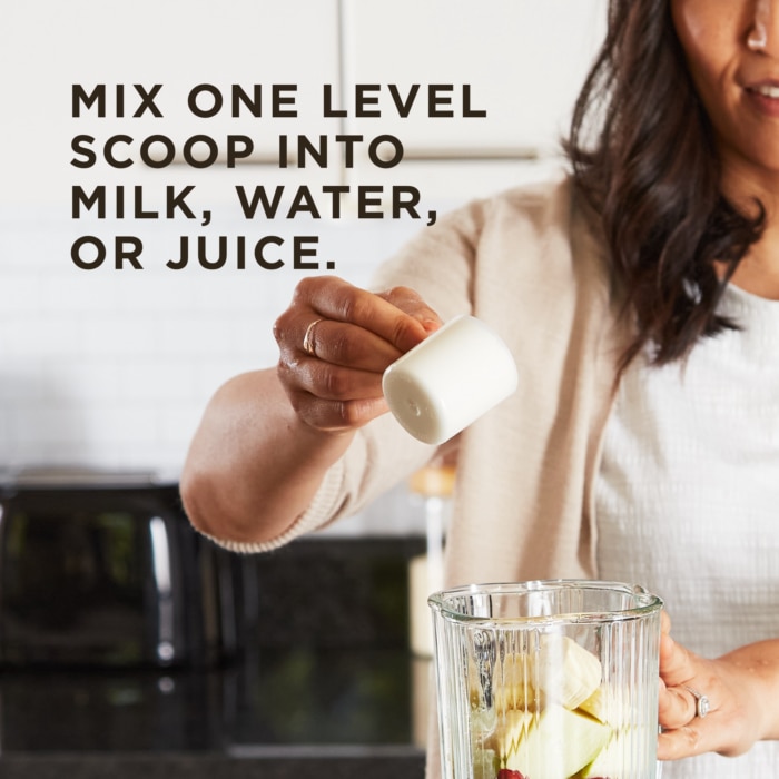 A woman holds a level scoop of Solgar's unflavored Whey To Go® Protein Powder over a blender cup. Text overlaid reads 