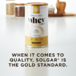 A container of Solgar's Whey To Go® plain protein powder on a kitchen counter, with text overlaid that reads 