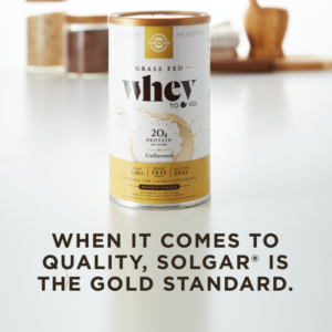 A container of Solgar's Whey To Go® plain protein powder on a kitchen counter, with text overlaid that reads "When it comes to quality, Solgar is the gold standard."