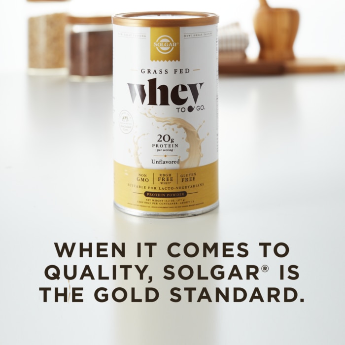 A container of Solgar's Whey To Go® plain protein powder on a kitchen counter, with text overlaid that reads 