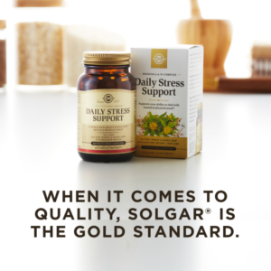 An amber glass bottle of Solgar's Daily Stress Support sits on a kitchen counter next to it's outer packaging. Text overlaid reads "When it comes to quality, Solgar is the gold standard."