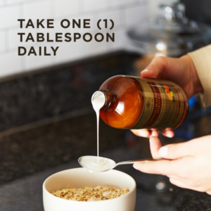 A bottle of Solgar's Liquid Calcium Magnesium Citrate with Vitamin D3 - Natural Orange-Vanilla Flavor pouring into a spoon held above a bowl of oats. Text reads "take one tablespoon daily"