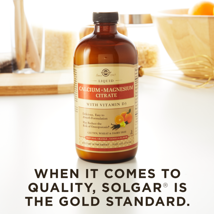 A bottle of Solgar's Liquid Calcium Magnesium Citrate with Vitamin D3 - Natural Orange Vanilla Flavor on a kitchen surface. Text reads "When it comes to quality, Solgar is the gold standard."