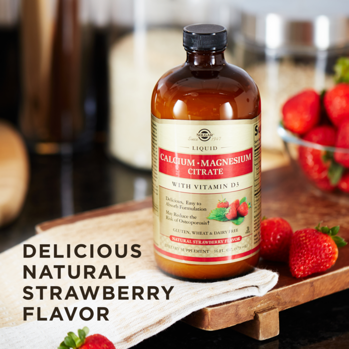 A bottle of Solgar's Liquid Calcium Magnesium Citrate with Vitamin D3 - Natural Strawberry Flavor next to a bowl filled with strawberries. Text reads "delicious natural strawberry flavor"