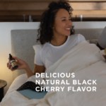A woman sitting up in bed smiling holds a bottle of Solgar's Liquid Melatonin 10 mg - Natural Black Cherry Flavor in her right hand. Text reads "delicious natural black cherry flavor"